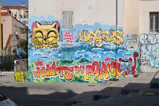 Graffiti e murales nel quartiere Le Panier a Marsiglia - colorato, gatto, scritta Les Minots du Panier